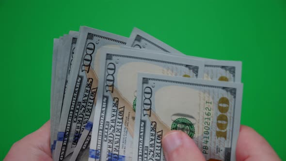 Count of Money From Hand to Hand on a Green Background alt