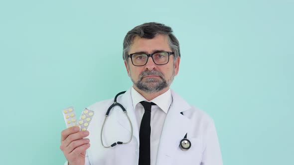 Senior Doctor Pharmacist Consultant Showing a Two Packs of Pills and Smiling in Camera alt