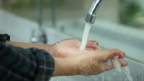 Close-Up young Asian woman wash hands in a public toilet at a public park.