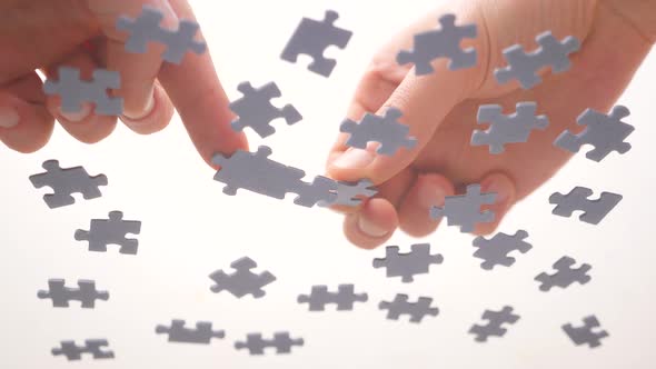 Assembling Jigsaw Puzzle. Pieces of a Jigsaw Puzzle Interconnecting By Male Hand. Fast Learning