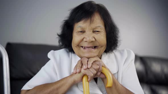 slow-motion of senior woman smiling with wooden cane