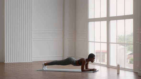 Athletic Young Black Woman Making Plank Exercise While Training At Home alt