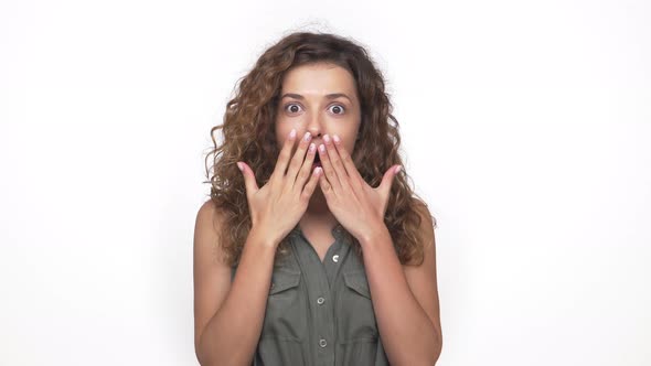 Brunette Nice Girl Surprisingly Closing Mouth with Hands Wideeyed Expressing Confusion Throwing Up alt