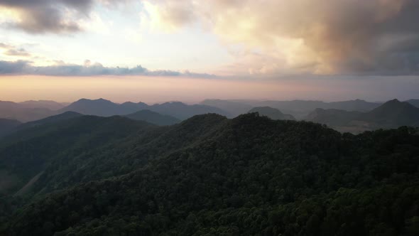 Aerial landscape view of greenery rainforest mountains before sunset by drone