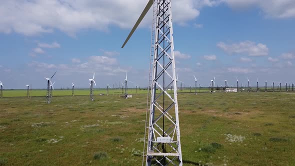 Drone footage of wind power plant with view going up to reveal landscape