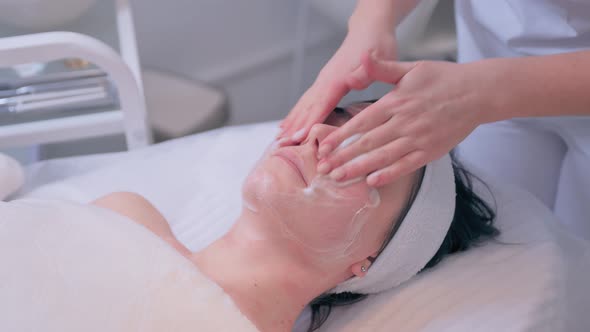 Cosmetologist Performs the Procedure of Cleansing and Moisturizing the Skin alt