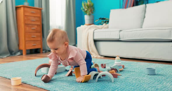 Cute Beautiful Little Blonde Girl with Big Eyes is Lying on Carpet Dressed in Pink alt