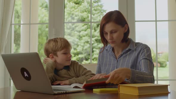 30s Mother Helping Her Son with Online Homework alt