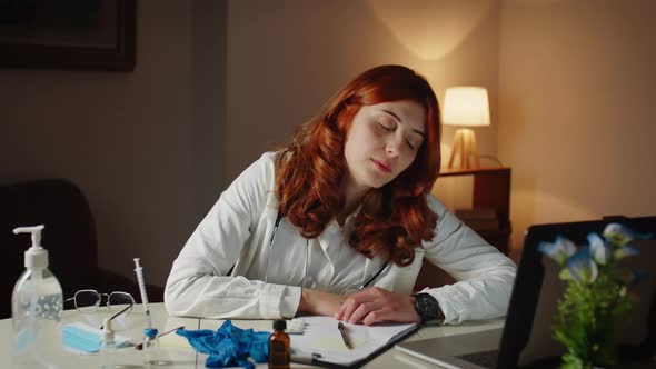 Young Female Doctor Sleeps on the Hospital Desk Tired of the Shift alt