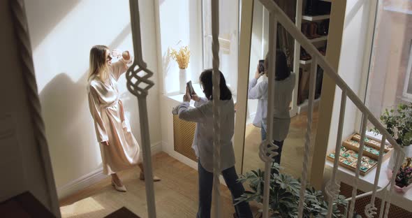 Two Young Girls Photographing New Clothes While Shopping alt