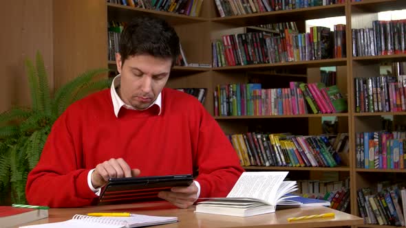 Student Using His Digital Tablet in a Library alt