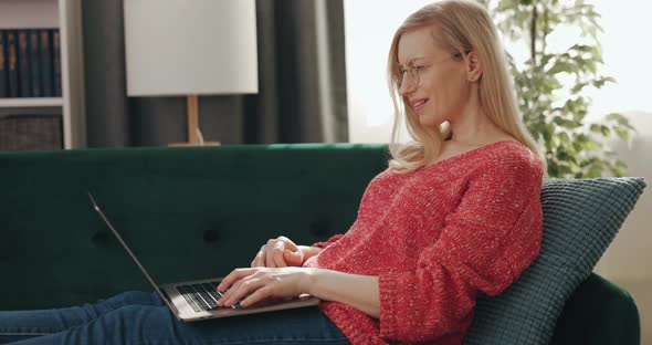 Woman on Couch Using Laptop