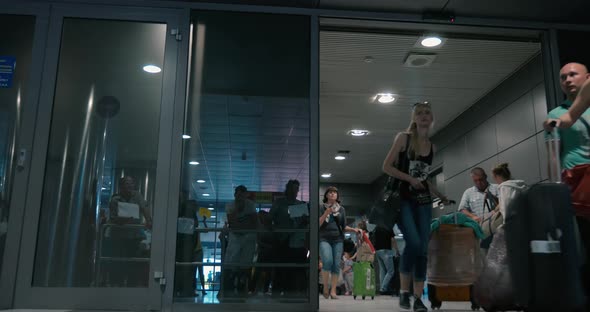 Travellers and People Meeting Them in Arrivals Hall alt