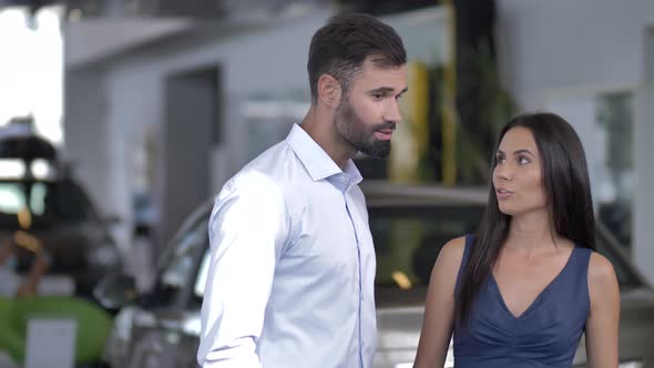 Couple of Interested Car Buyers at Auto Dealership alt
