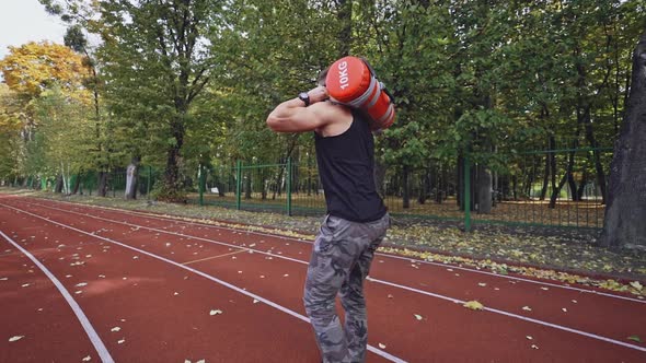Strong athlete doing hard exercises on the open air. Sporty athlete training alt