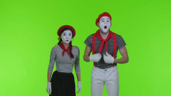 Surprised Mimes Look At The Camera On A Green Background