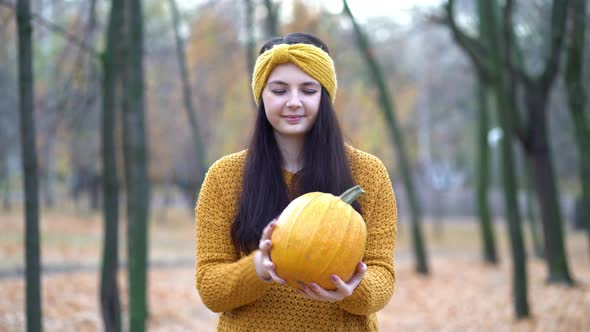 Woman Holding Pumpkins in Hands on an Autumn Sunny Day in the Forest