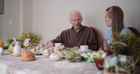 Happy Easter - Grandfather and Granddaughter Spending Easter Together Talking at Home. alt
