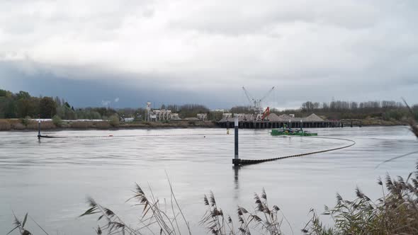 Industrial barge and equipment used to clean river water from trash, time lapse shot alt