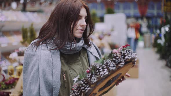 A Young Beautiful Woman Walks Around the Store and Selects Christmas Decorations and Decorations to alt