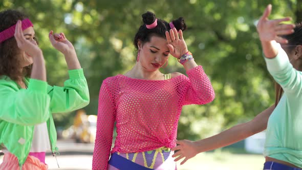 Portrait of Annoyed Caucasian Retro Woman Putting on Sunglasses As Cheerful Friends Hugging and alt