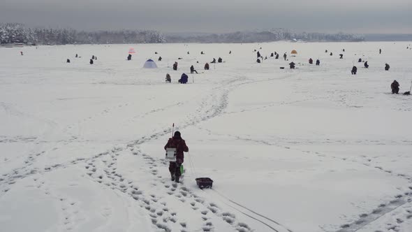 Fisherman Walks on Frozen Lake Winter Fishing Championship Snowy Lake alt