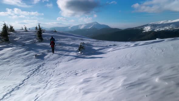 Couple of Hikers Walking Towards the Summit in Winter