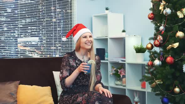 Beautiful Girl in Santa Hat Is Waiting and Emotionally Celebrating the New Year's Coming alt