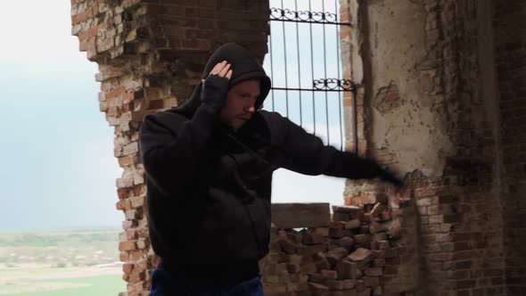 Man boxer in the hood trains beats in an abandoned building. Shadow Boxing. Slow motion. alt