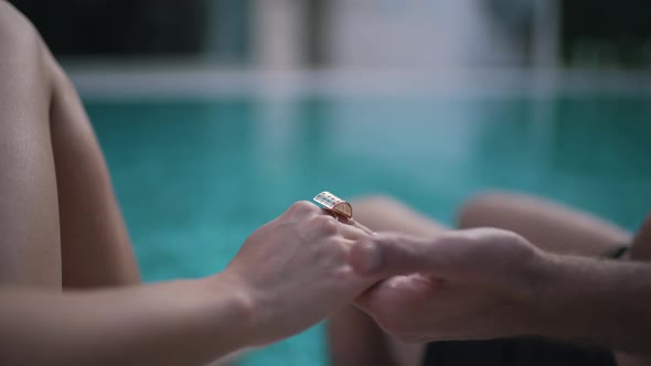 a Man with a Girl Hold Hands By the Pool