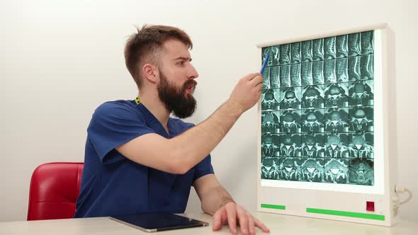 Physiotherapist Shows Patient an Xray Image of Skeleton of Bones alt