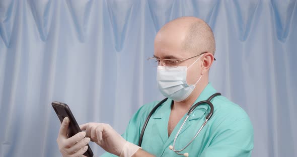 The Doctor is Looking for Information in the Mobile Phone on a Blue Background alt