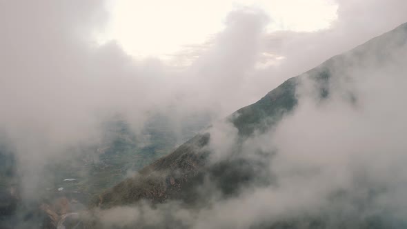 Flying over of the clouds inside Canyon del Colca in the Andes Mountains in Peru 4K