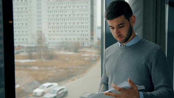 Young Boss Looking at Startup Project Standing By Window in Modern Company