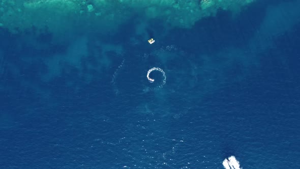 aerial view of a fast speedboats driving around in the circle and making beautiful shapes 