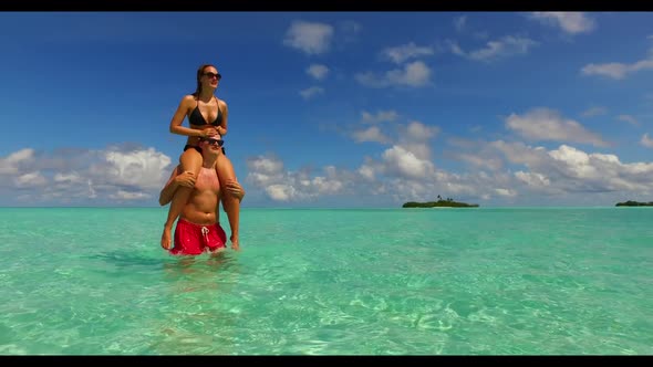 Boy and girl tanning on tropical seashore beach vacation by clear sea and white sandy background of  alt