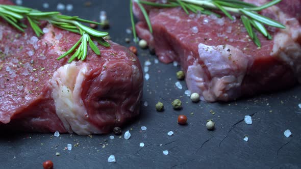 Raw Steak with Seasonings on a Dark Background