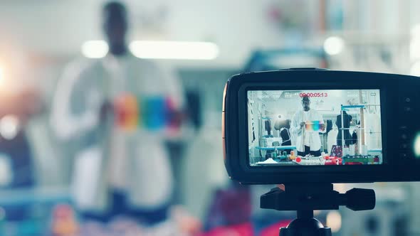 Camera is Filming a Vlog with an African Tailor alt
