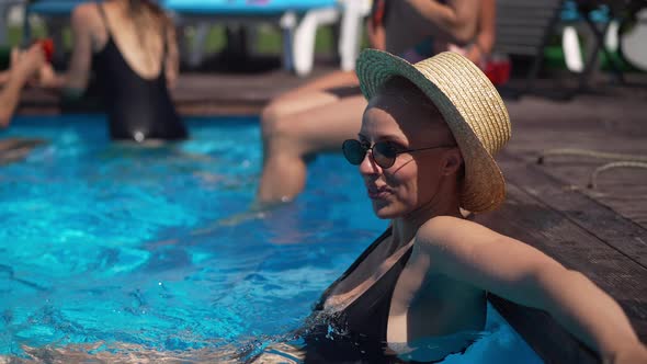 Side View Portrait of Smiling Beautiful Caucasian Woman in Sunglasses and Straw Hat Sitting in alt