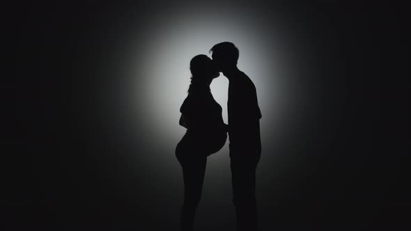A Man Kisses a Pregnant Woman Without Faces alt