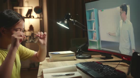 Teenage Girl Headache While Distance Learning With Online Teacher On Computer Screen From Home alt