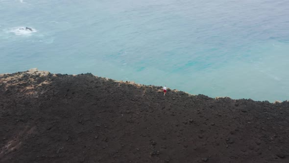 Man Standing on Cliff of Capelinhos Volcano Faial Island Azores Portugal alt