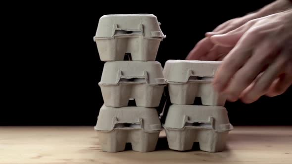 Man Stacking Egg Paper Packaging. Slow Motion. alt