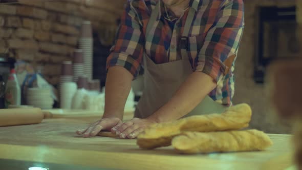 A Male Baker Is Kneading Dough and Making Bread with a Rolling pin.Cooking Process, Culinary, recipe alt