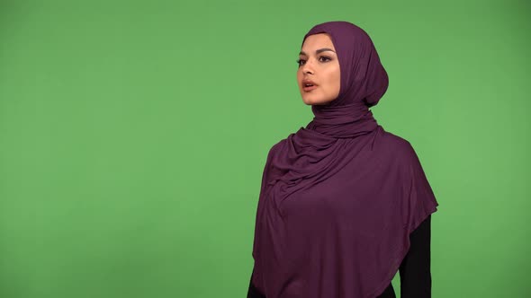 A Young Beautiful Muslim Woman Looks Around in Awe  Green Screen Background