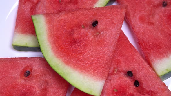 Close Up. Pieces of Watermelon Rotate in a Circle on a White Background