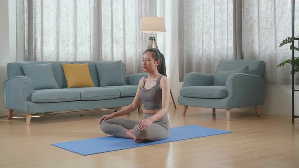 Young Asian Athletic Female Meditating During Workout On Yoga Mat At Home. Healthy Lifestyle alt