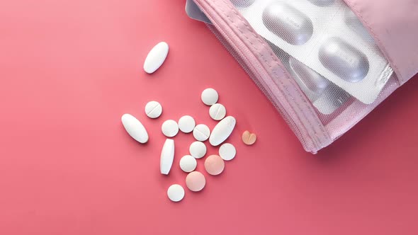  White Pills and Blister Pack on Pink Background  alt