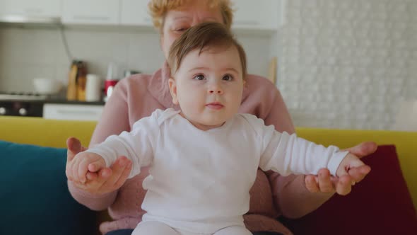 Happy Caucasian Grandmother Playing and Holding Her Little Granddaughter at Home alt