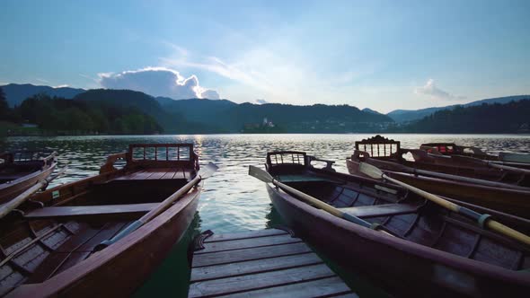 View of Moored Wooden Boats and Mountains Near Bled Lake alt